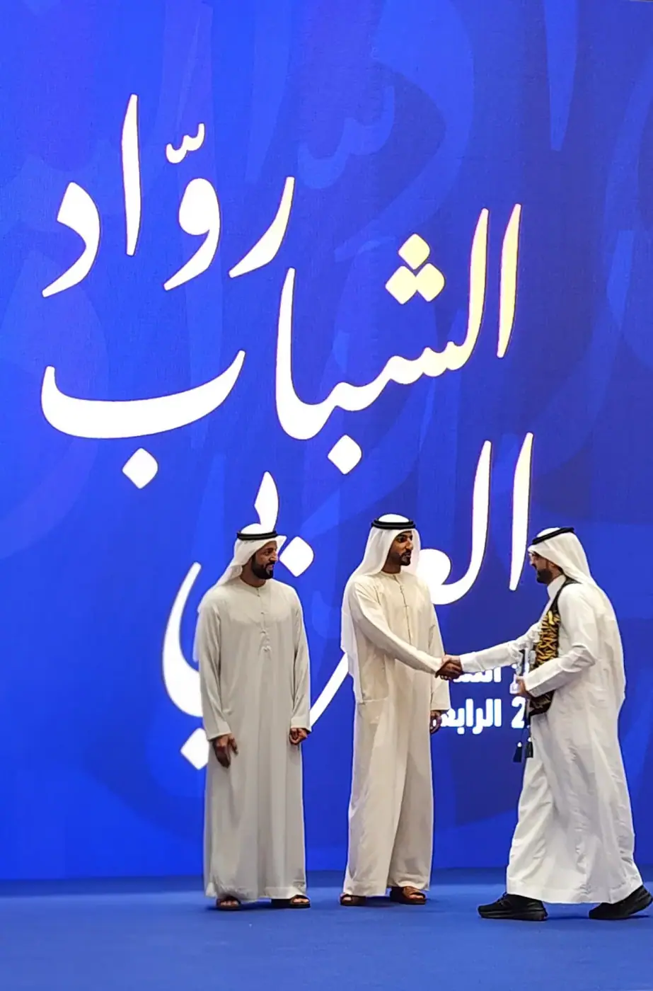 لحظة تسلّم الدرع على المسرح في أبوظبي